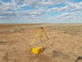 Trimble receiver placed over survey mark in red soil