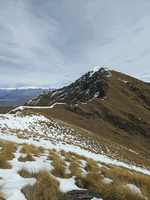 Ridge on a tussocky hill with small amount of snow on the tops