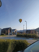 Hot air balloon flying low over a suburban area